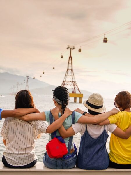 people holding shoulders sitting on wall